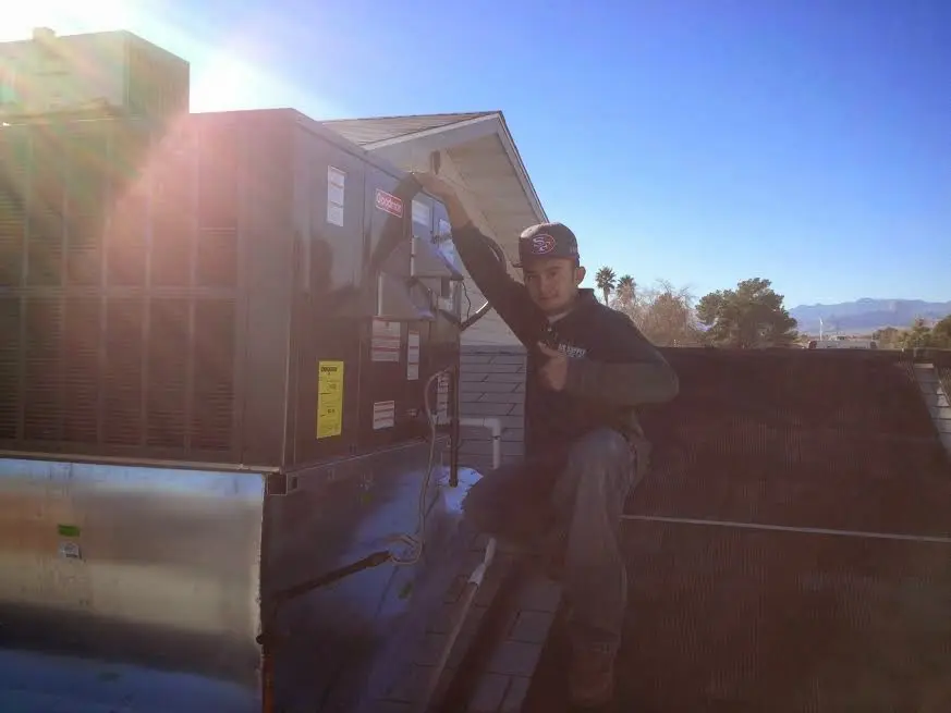 HVAC technician performing Air Duct Repair on a rooftop unit in Maryville